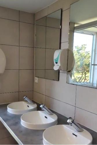 a bathroom with two sinks and a mirror at Auberge Granit Rose - Hébergement partagé en Auberge de Jeunesse - Vue sur mer - Dortoir mixte & Camping in Trébeurden