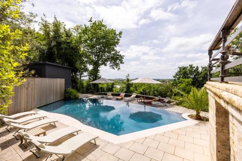 a swimming pool with lounge chairs and a swimming pool at chalet baron in Lormont