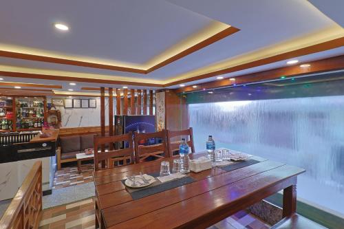 a dining room with a table and a large window at OYO 839 Hotel Middle Temple in Kathmandu