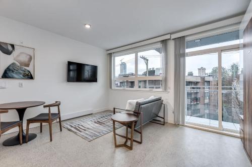 a living room with a table and chairs and a window at Modern Downtown Studio Bedroom Walk Everywhere in Vancouver