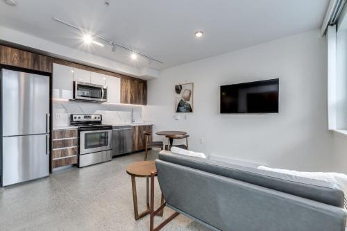 a living room with a couch and a kitchen at Modern Downtown Studio Bedroom Walk Everywhere in Vancouver
