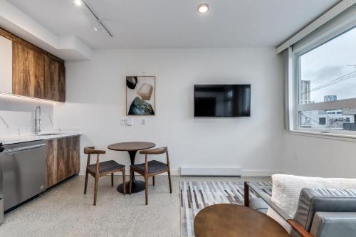 a kitchen and living room with a table and chairs at Modern Downtown Studio Bedroom Walk Everywhere in Vancouver