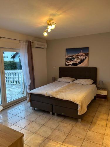 a bedroom with a large bed and a large window at Villa Nikki in Bilice