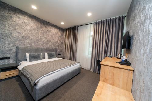 a bedroom with a bed and a television in it at Inga Hotel Yerevan in Yerevan