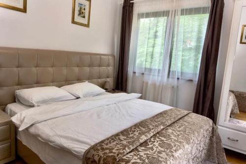 a bedroom with a large bed with a window at Apartament Stanca Piticului in Sinaia