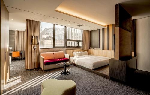 a hotel room with a bed and a chair at Hotel Geight Taipei in Zhonghe