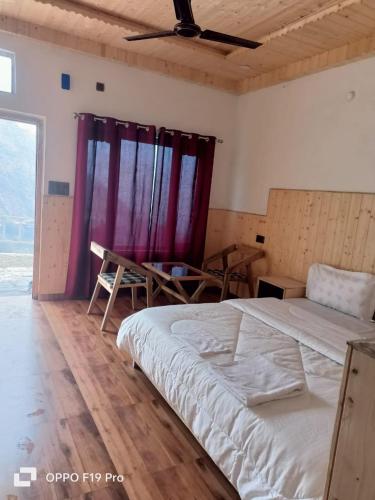 a bedroom with a large bed and a purple curtain at The Holiday Resort in Kailāna