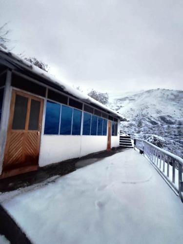 a house with snow on the ground next to a building at The Holiday Resort in Kailāna
