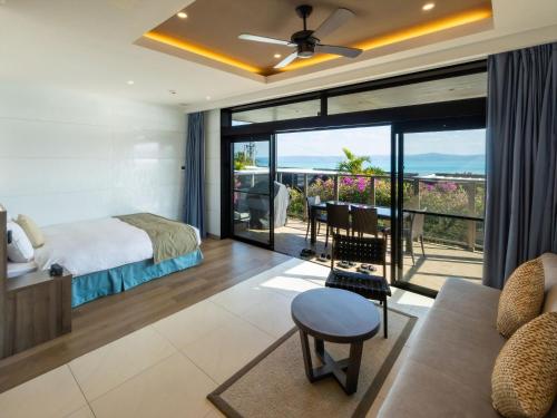 a bedroom with a bed and a view of the ocean at One Suite THE TERRACE in Nakijin