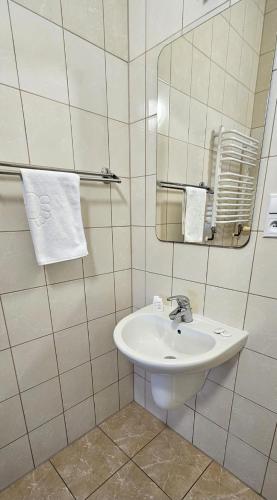 a bathroom with a sink and a mirror and towels at NOVA Motel in Międzyrzecz