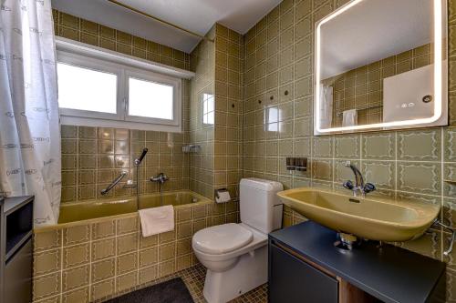 a bathroom with a sink and a toilet and a tub at Appartement Tzoum'Azur 6 in La Tzoumaz