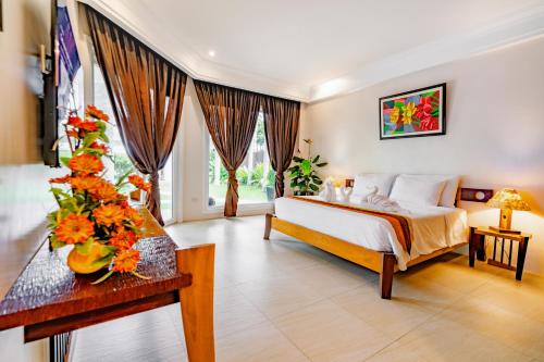 a bedroom with a bed and flowers on a table at Casa Negrense Private Resort in Dauin