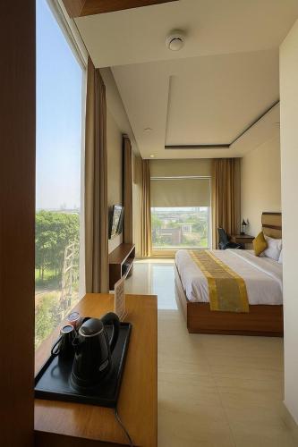 a hotel room with a bed and a large window at Comfort By Choice in Amritsar