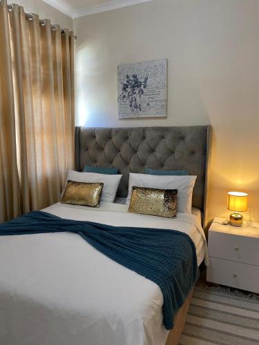 a bedroom with a large bed with a large headboard at Maerua Mall Units LUXE ACCOMMODATION in Windhoek