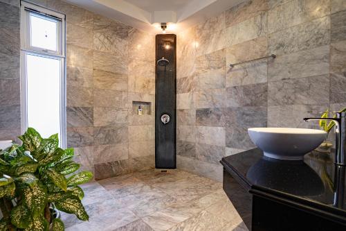 a bathroom with a sink and a plant at Casa Negrense Private Resort in Dauin