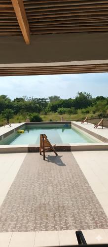 a wooden bench sitting in front of a swimming pool at REFUGE du MONT AGOU in Liatonou