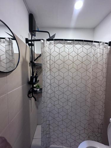 a bathroom with a shower curtain and a mirror at Charming & Comfortable Studio Haven in Lapu Lapu City