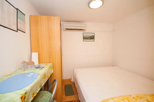 a small room with two beds and a table at Studio Marin in Baška