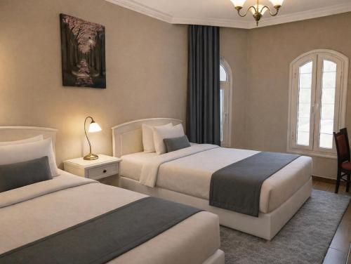 a hotel room with two beds and a window at Evermond Suites in Alexandria