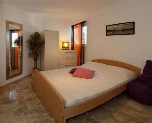 a bedroom with a bed with a red pillow on it at Apartments Paradise With Amazing Sea View in Vinišće