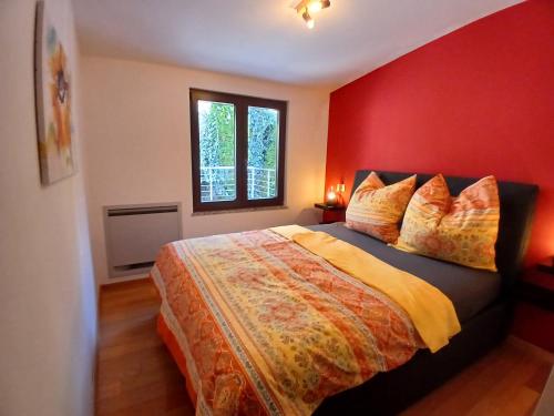a bedroom with a bed with a red wall at RED House Rabac in Rabac