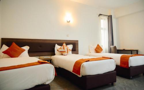 a hotel room with two beds and a window at Eliper Hotel in Gatura