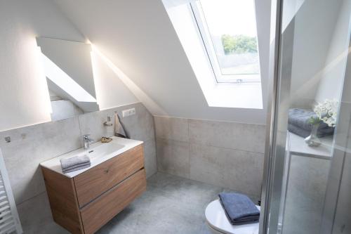 a bathroom with a sink and a toilet and a window at Ferienwohnungen Lindleshof in Leinach