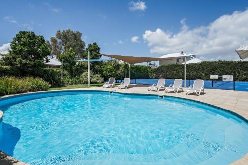 a large swimming pool with chairs at Geographe Cove Resort in Dunsborough