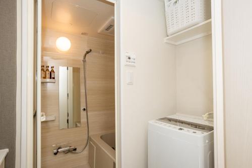 a small bathroom with a washer and dryer at Mi-Hotel Nakano- Shinjuku Direct 中野南台 in Tokyo