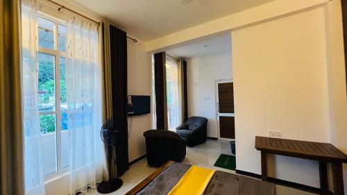 a living room with a chair and a window at Adams Peak Lake Resort in Nallathanniya