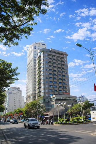 a tall white building on a city street with cars at MissBamboo Hotel Nha Trang in Nha Trang