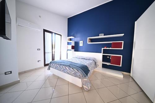 a bedroom with a bed and a blue wall at La Terrazza Sidicina Home in Teano