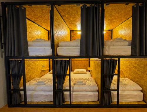 a room with three bunk beds in a room at Softbox Hostel in Ban Laem Thong Lang