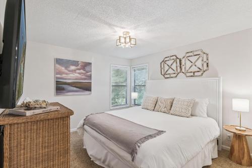 a white bedroom with a bed and a window at Harbour Oaks, Unit 618 in Saint Simons Island