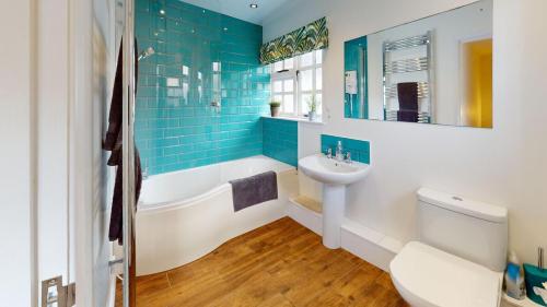 a bathroom with a tub and a sink and a toilet at CROYDE WHITE HOUSE 4 Bedrooms in Croyde