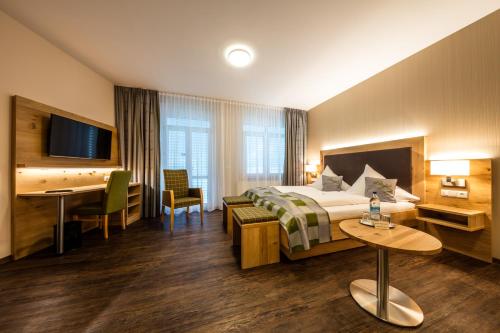 ein Hotelzimmer mit einem Bett und einem Schreibtisch in der Unterkunft Landhotel Endhart in Landsberg am Lech