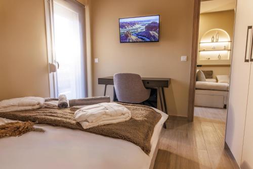 a bedroom with a bed with a desk and a chair at Asana luxury apartment in Kozani