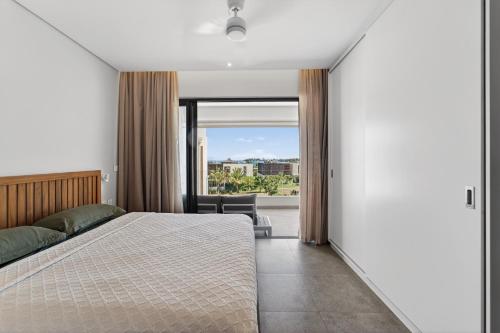a bedroom with a bed and a large window at Beachfront sea view apartment in Petite Case Noyale