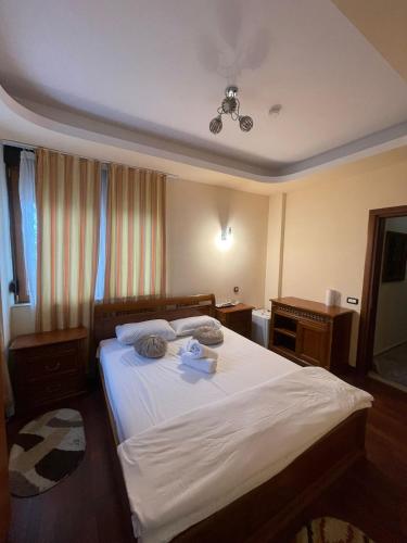 a bedroom with a bed with white sheets and a ceiling at El Locanda Boutique Hotel in Constanţa