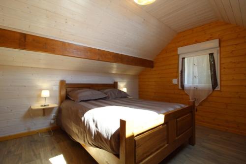 une chambre avec un lit dans une cabane en bois dans l'établissement Gîte à rufus, à Le Ménil