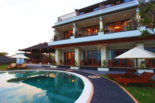 a hotel with a swimming pool in front of a building at Puri Pandawa Resort in Uluwatu