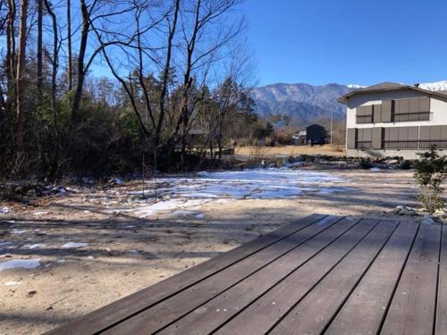 a wooden bench sitting on top of a field at 安曇野市穂高温泉郷Vila湯仙望 in Azumino