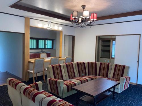 a living room with couches and a table and a dining room at 安曇野市穂高温泉郷Vila湯仙望 in Azumino