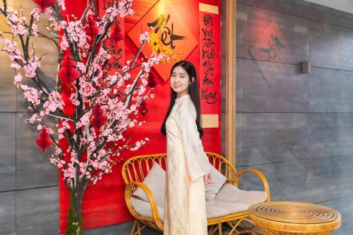 a woman in a white robe standing next to a wall at SHI HOUSE by Haviland in Danang