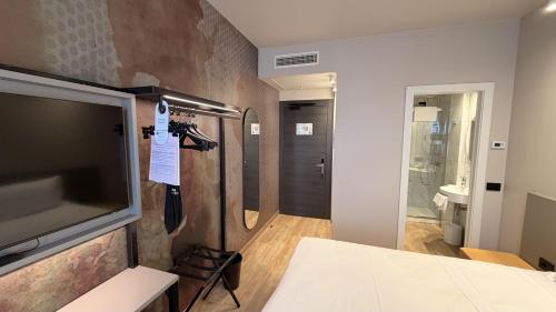 ein Zimmer mit Fernseher und Badezimmer in der Unterkunft Hotel Astoria Sure Hotel Collection By Best Western in Mailand