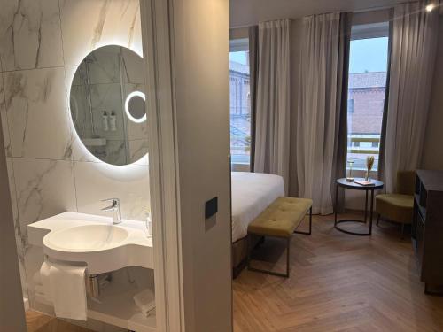 a bathroom with a bed and a sink and a mirror at Best Western Madison Hotel in Milan