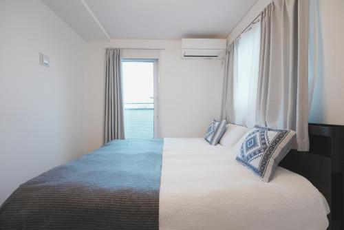 a bedroom with a large bed with a large window at Dorothy Inn Spacious 4LDK New Build 97sqm Up to 10 Guests Free Private Parking Near JR Higashi Jujo Station 3 Minute Walk in Tokyo