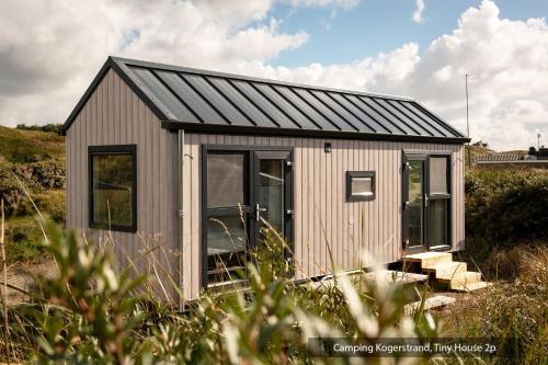 a small shed with a black roof at Texelcampings - Kogerstrand in De Koog