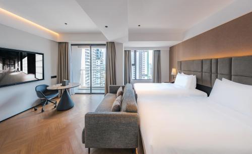 a hotel room with a large bed and a couch at Intercity Hotel & Serviced Apartment Phnom Penh Downtown in Phnom Penh