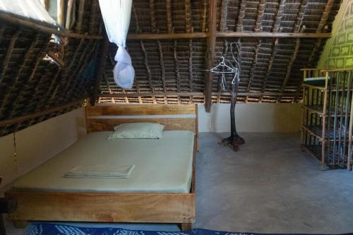 a room with a bed in a thatched room at Rasal homes in Gazi